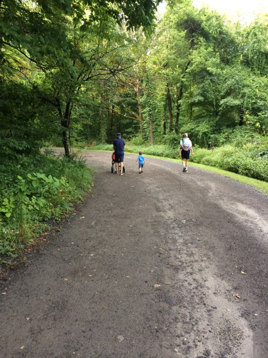 Young man with stroller, little boy, and old man with young girl.